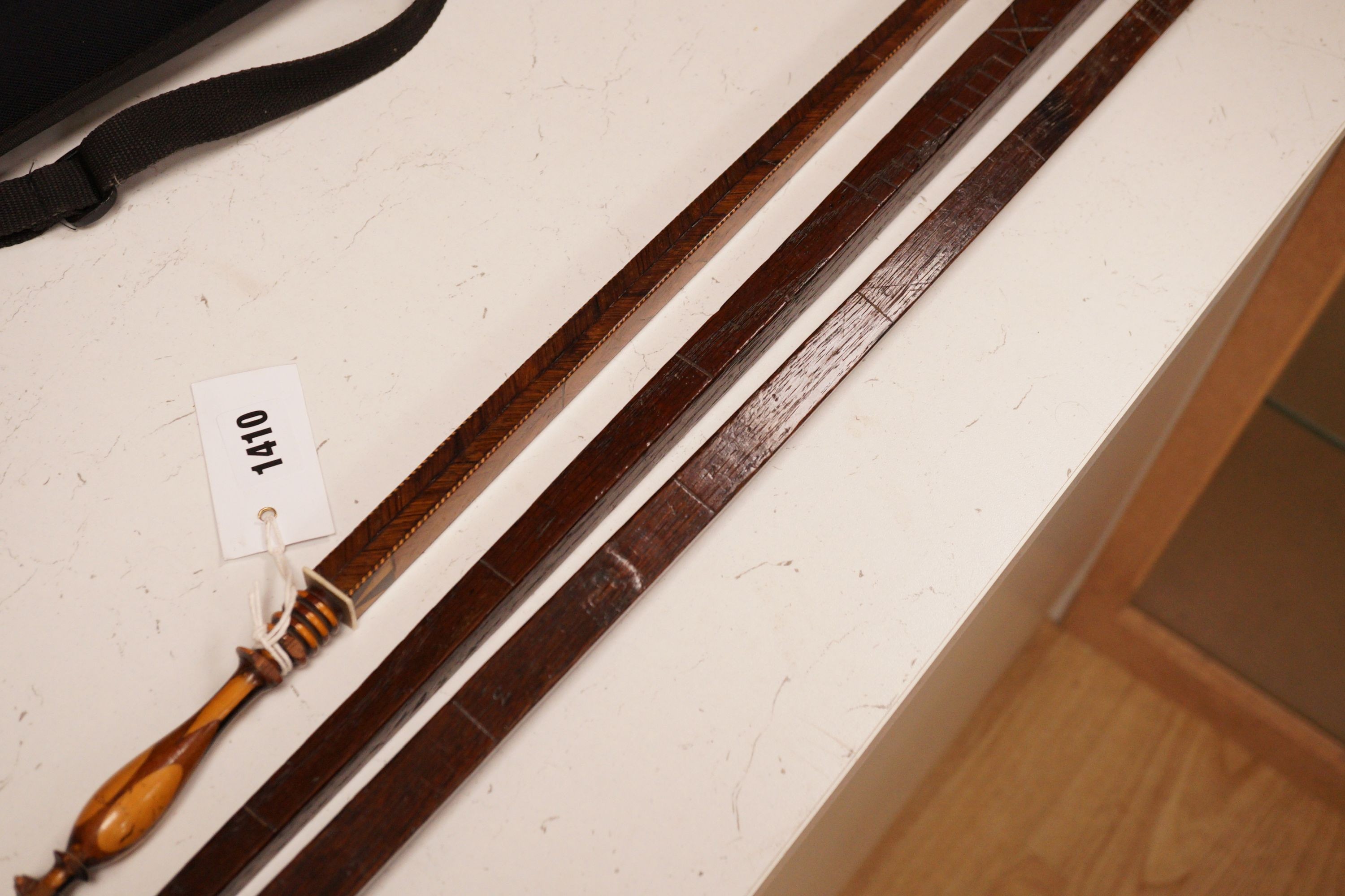 Three assorted 19th century treen measuring sticks to include a kingwood feather banded and marquetry inlaid measuring stick with stickware finial